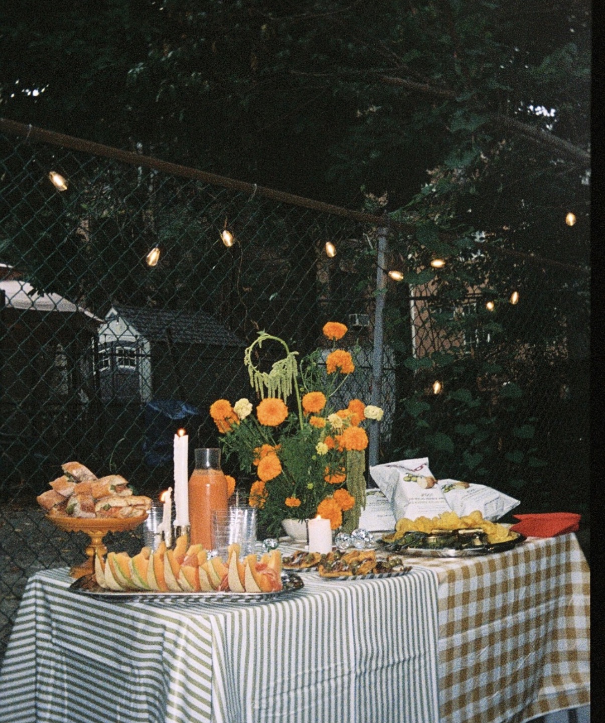 Backyard supper club dinner table styled with marigolds and candlelight in New York City